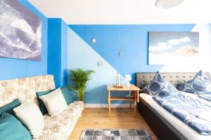 um quarto azul com uma cama e um sofá em - Sea Apartment Duisburg Center & Parking spaces & Kingsize Bett - Central Station Hbf - em Duisburg