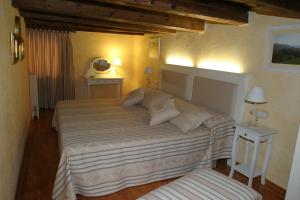 1 dormitorio con 1 cama grande y 2 mesas en Casa rural Daudén, en Cantavieja