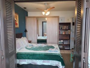 ein Schlafzimmer mit einem Bett und einem Bücherregal in der Unterkunft Apt com vista para o mar in Capão da Canoa