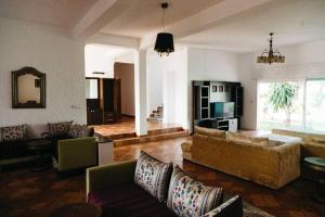 Villa Vue sur la Méditerranée في كابو نيغرو: غرفة معيشة مع كنب وأريكة وتلفزيون