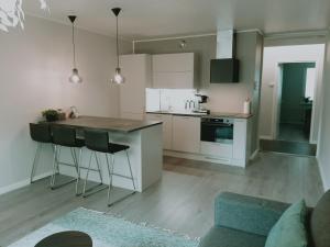 eine Küche mit weißen Schränken und einer blauen Couch in der Unterkunft Kaski, three-room condo in a prime location, free parking in Tampere