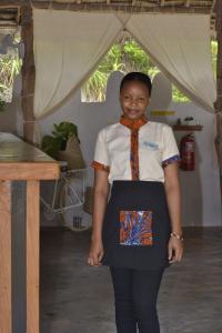 une fille portant une cravate orange et une chemise blanche dans l'établissement Mem Luxury Apartments and Hotel, à Paje