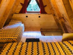 an attic room with two beds and a window at Etno Cottages Komarnica Authentic Peaceful Mountain Getaway in Šavnik