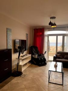 a living room with a couch and a tv at Spacious Penthouse Chalet at Telal Sokhna in Ain Sokhna