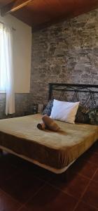 - un grand lit dans une chambre dotée d'un mur en pierre dans l'établissement Casa Vivi, à Vallehermoso