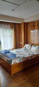 Tigerhill Homestay في دارجيلنغ: سرير كبير في غرفة مع نافذة