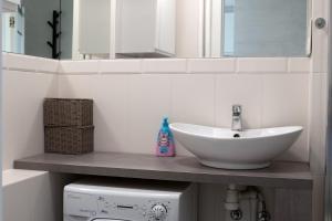 a bathroom with a sink and a mirror and a washing machine at Na chmury i góry - apartament in Kłodzko