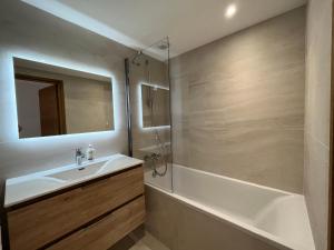 a bathroom with a sink and a shower and a tub at Newly renovated 7-9pers Luxury Chalet in Meribel Centre 85m2 3BR 3BA with stunning Mountain View in Méribel