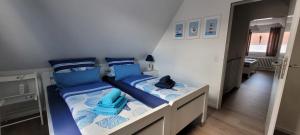 una camera con 2 letti con cuscini blu di Ankerseele a Hage