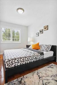 a bedroom with a bed with a black and white comforter at The cozy corner House in the Richmond Hill in Richmond Hill
