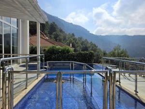 una casa con una piscina con montañas en el fondo en Alanya Family Paradise Sea View, en Alanya