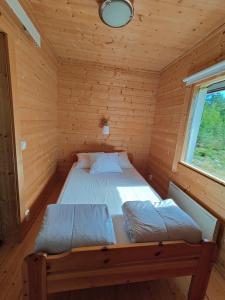 a bedroom with a bed in a wooden cabin at Viherpeukalo lomamökki in Parkano