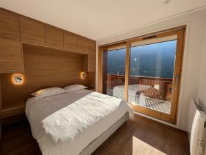 a bedroom with a bed and a large window at Newly renovated 7-9pers Luxury Chalet in Meribel Centre 85m2 3BR 3BA with stunning Mountain View in Méribel