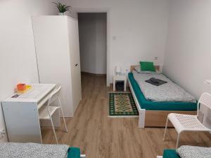 キェルツェにあるApartament Zagórze, bezpłatny ogrodzony parking, Netflixのベッド2台、デスクが備わる小さな客室です。