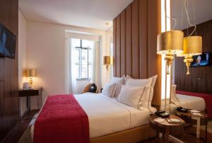 a hotel room with a large bed and a window at The 7 Hotel, Suites, Studios & Apartments in Lisbon