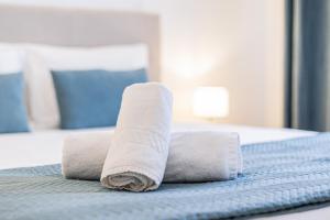 a rolled up towel on top of a bed at Beachside Bliss in Armação de Pêra