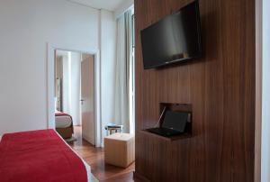 a hotel room with a television on a wooden wall at The 7 Hotel in Lisbon