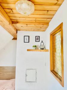 a bedroom with a wooden ceiling and a window at Haus Mali in Heiligenberg