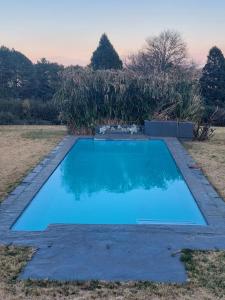 a blue swimming pool in the middle of a field at 9 Stoney Way House in Underberg