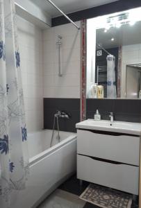 a bathroom with a tub and a sink and a bath tubermott at Apartament Panoramic ALBA IULIA in Chişinău
