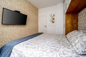 a bedroom with a bed and a flat screen tv on the wall at Apartment Urban Garden in Belgrade