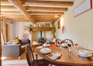 a dining room with a table and chairs and a living room at 1 New Thatched Cottage in Edingthorpe