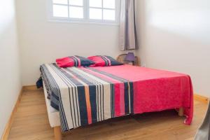 een slaapkamer met een bed met een gestreepte deken en een raam bij Location saisonnière bel appartement in Les Trois-Îlets