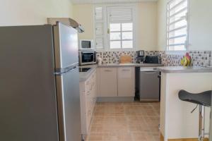 eine Küche mit einem Kühlschrank aus Edelstahl in der Unterkunft Location saisonnière bel appartement in Les Trois-Îlets