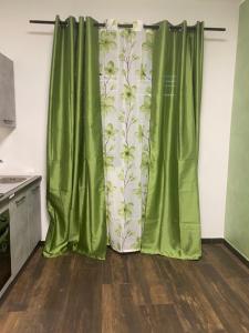 una cocina con cortinas verdes en una habitación en Casa Vacanza Mangiafico, en Solarino
