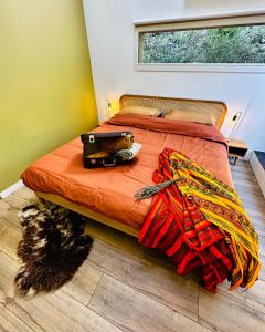 - un lit avec une couverture orange et un ordinateur portable dans l'établissement B&B Les Têtes de Mules - Adults Only, à Gémenos