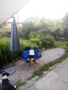 una mesa, dos sillas y una sombrilla en Chemin des Écoliers 2 chambres doubles, en Soueich