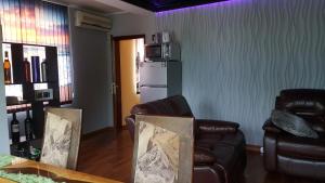 een woonkamer met 2 leren stoelen en een koelkast bij Villa Morska in Chernomorets