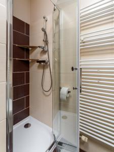 a bathroom with a shower with a glass door at Apartament Poranna Kawa in Rzeszów +6 photos