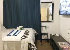 um quarto com uma cama, uma mesa e um espelho em Lovely Room In a Shared Apartment with Pool em Joanesburgo