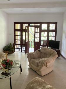 a living room with a couch and a glass table at The Blue Heron Villa in Kandy