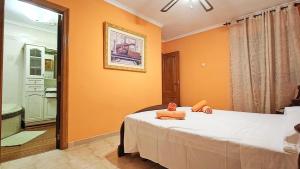 a bedroom with a bed with orange walls and a bathroom at La Bohemia Casco Antiguo in Calpe