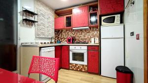 a kitchen with red cabinets and a white refrigerator at La Bohemia Casco Antiguo in Calpe