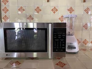 eine Mikrowelle auf einer Küchentheke neben einem Mixer in der Unterkunft Linda Villa al lado del Club de Tenis in Cuernavaca