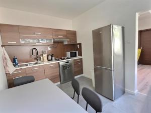 a kitchen with a table and a stainless steel refrigerator at Free Wifi - Urban Oasis Rentals in Bratislava