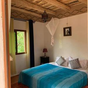 a bedroom with a blue bed in a room at Riad Des Vieilles Charrues in Boumalne