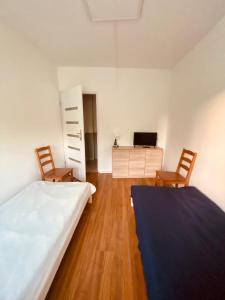 1 Schlafzimmer mit einem Bett, 2 Stühlen und einem Schreibtisch in der Unterkunft Hostel Warszawa Ursynów in Warschau