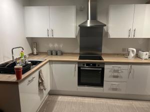 a kitchen with white cabinets and a stove top oven at Salford Manchester in Manchester