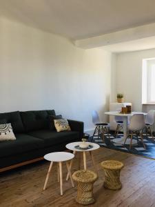 uma sala de estar com um sofá preto e mesas em Le nid de Saint Bedan em Nantes