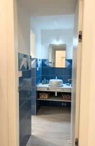 ein blaues Badezimmer mit einem Waschbecken und einem Spiegel in der Unterkunft CASA LARROSA in Meta