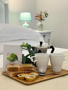 ein Tablett mit zwei Tassen und einem Tee-Set auf dem Bett in der Unterkunft CASA LARROSA in Meta