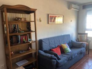 a blue couch in a living room with a book shelf at Apartamento en las salinas de Cabo de Gata in El Pozo del Cabo