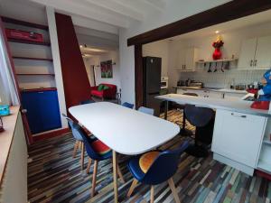a kitchen with a white table and some chairs at Chemin des Vignerons in Metz