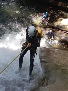 Ein Mann überquert einen Fluss mit einem Seil in der Unterkunft Selvatica EcoHostal in San Carlos