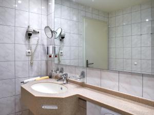 a bathroom with a sink and a mirror at Hotel Münster in Emmelshausen