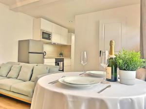 einem weißen Tisch mit Weingläsern und einer Couch in der Unterkunft Les fauvettes - Centre ville in Épernay